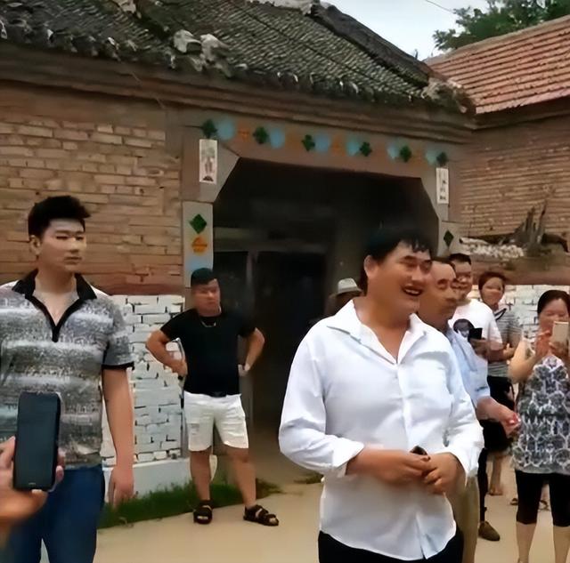 大衣哥朱之文的近况，大衣哥朱之文近况揭晓时间（穿西装身姿挺拔被众人围绕）