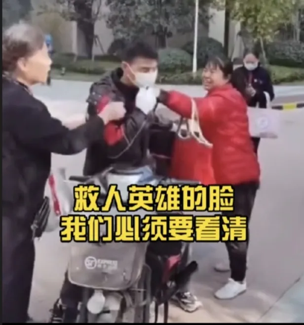 武汉一顺丰快递员在小区被大妈围堵，非要让他露脸，因为他刚救了一家三口。