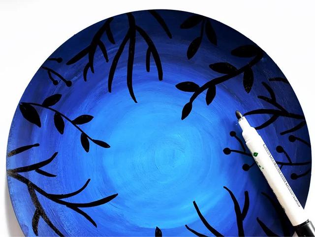 渐变的蓝色背景待背景的颜料干后用记号笔围绕圆形画幅描绘出草木茂盛