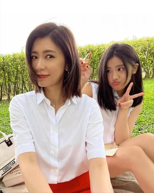 贾静雯和她16岁的女儿去野餐。她穿着白衬衫，气质很好，看起来像个妹子。
