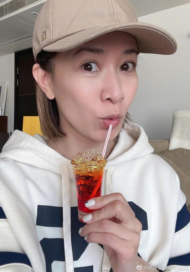 43岁的胡杏儿和她的第三个儿子一起庆祝丈夫的生日。她的前额头发稀疏，白发浓密。
(图10)