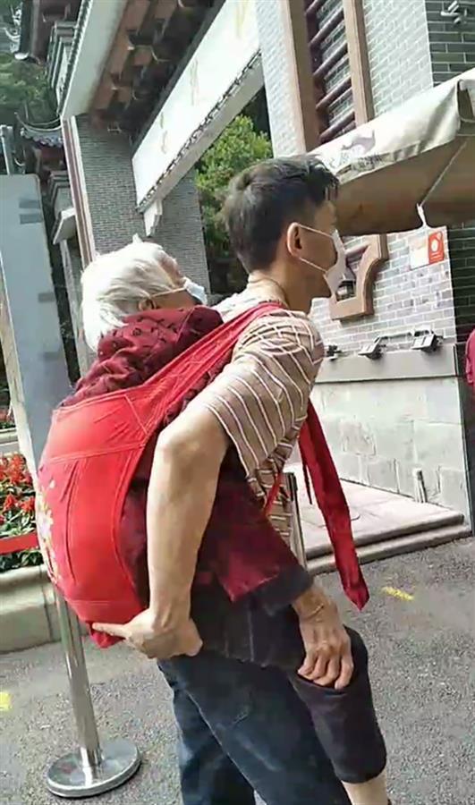 广东男子背九旬母亲爬山游览，许多游客感动为他擦汗