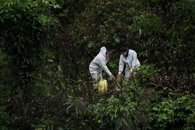 救援人员穿防护服泥泞中搜寻