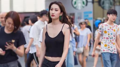 小姐姐上半身选择了一件黑色吊带背心，这款背心采用纯棉面料的设计，在腰间有着收