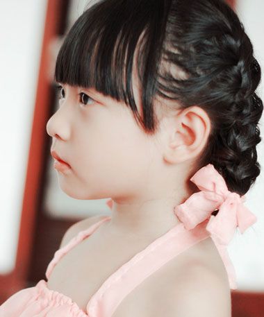 女童齐刘海编盘发发型黑色的头发梳漂亮的内扣发型,发顶上的头发顺着