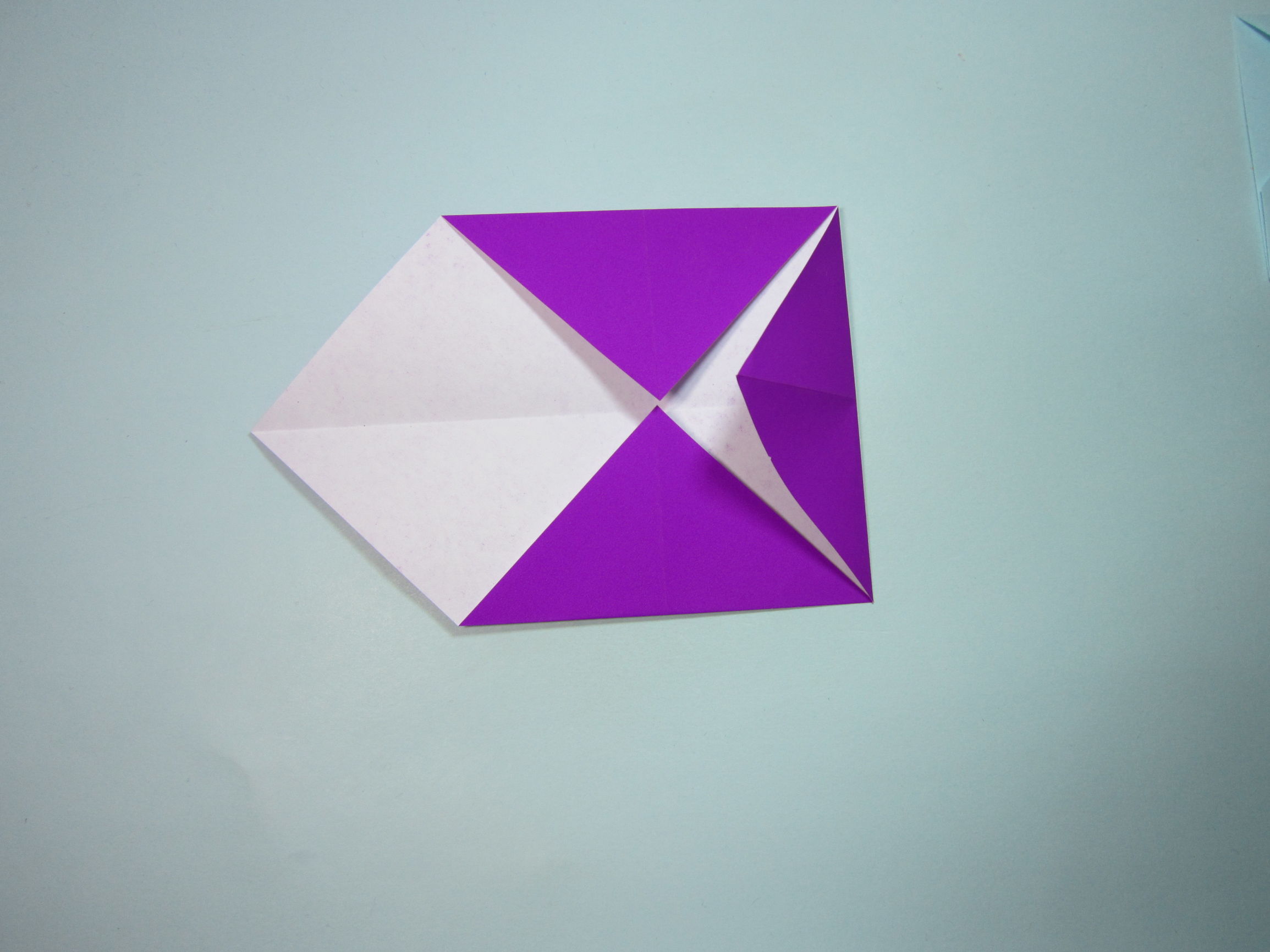 第1步,首先准备一张正方形纸,将纸张的四个角分别沿着对角线两两对折
