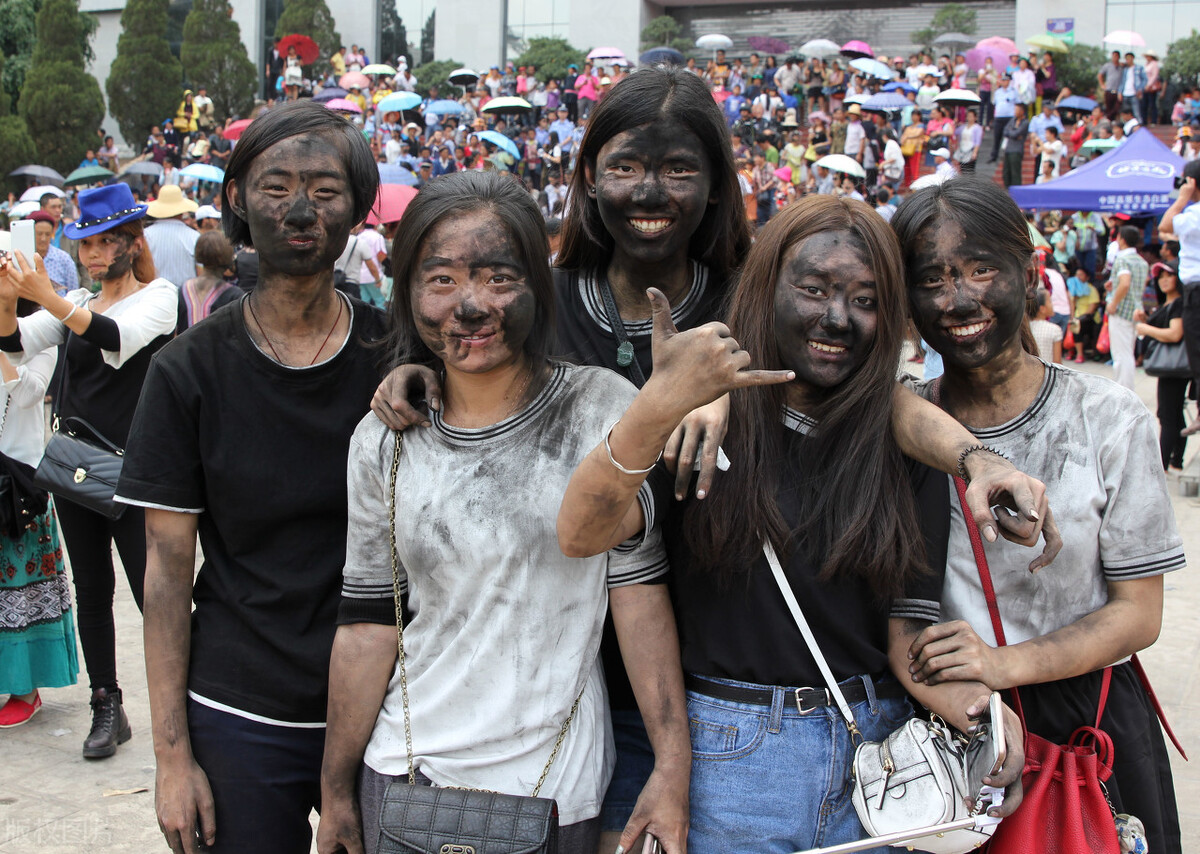 每年7月,上万彝族同胞和游客一起互相抹黑脸