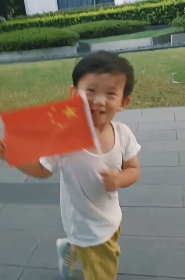 应采儿罕晒次子视频，HoHo举着红旗一路小跑，露小乳牙萌态尽显