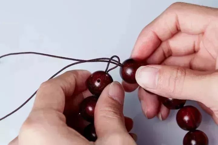 首先双线穿绳,将珠子依次穿入绳子中,记住三通用作末尾一颗.
