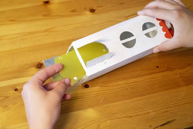 3,根据牛奶盒大小,剪一张略小的油蜡纸,粘贴在牛奶盒的内部.