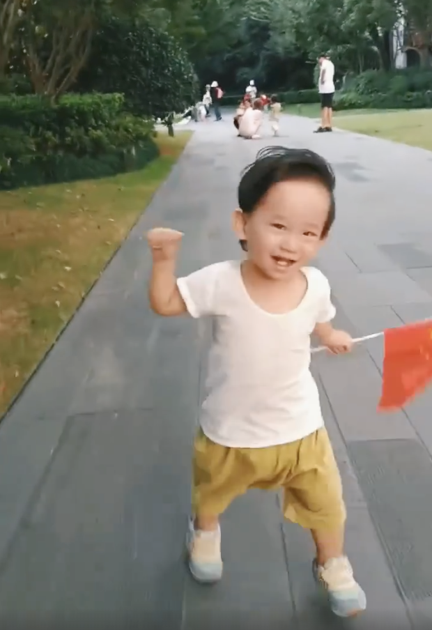 应采儿罕晒次子视频，HoHo举着红旗一路小跑，露小乳牙萌态尽显