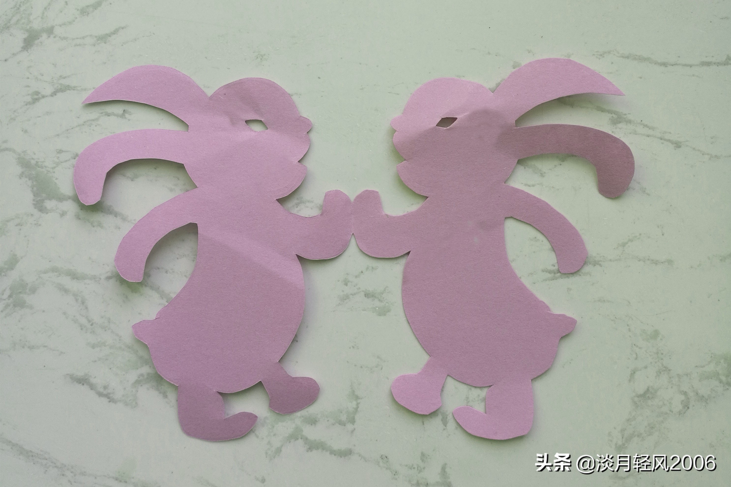 动物剪纸怎么做(幼儿园简单剪纸手工，一张纸剪出两个小兔子，有教程)