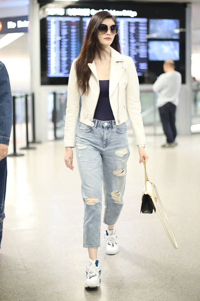 何穗的气质很耐看,白色皮衣干净素雅,走机场如走t台