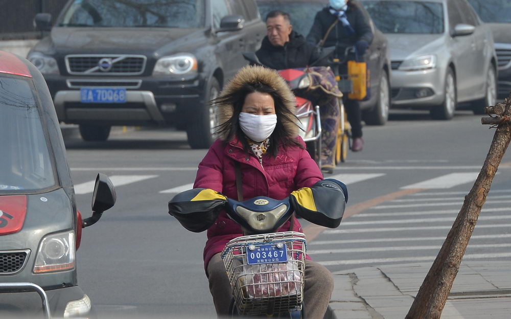 沈阳迎来黄尘大风天气 街头市民顶风骑行