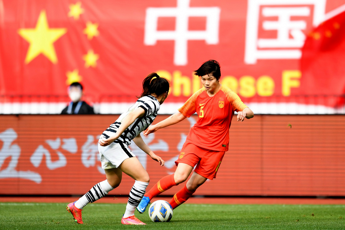 中国女足队员上海姑娘张馨在比赛中拼抢中国女足队员娄嘉惠(左)和韩国