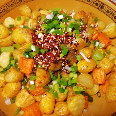 至金黄表皮微微发皱捞出,放入两勺盐,两勺蒜末,一勺孜然粉,半勺花椒粉