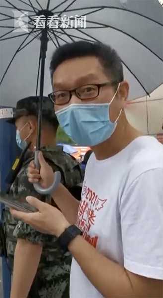 上海中考首日降雨 送考家长默默为执勤武警撑伞