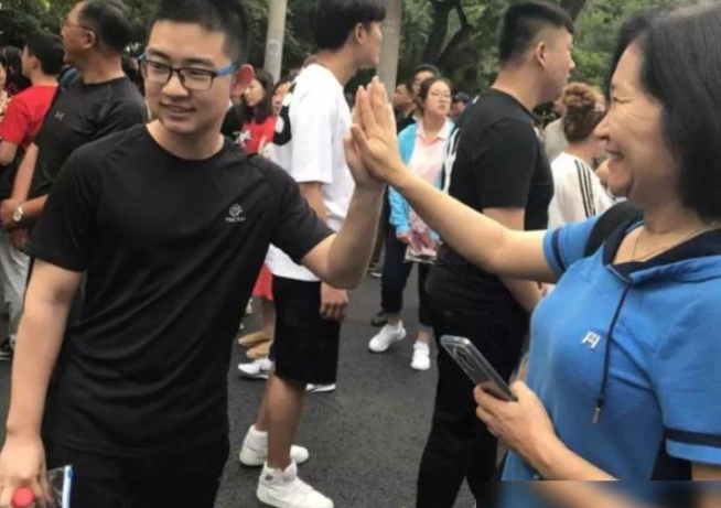 家长为高考生花式应援，穿旗袍拿向日葵是常态，紫色裤衩才硬核