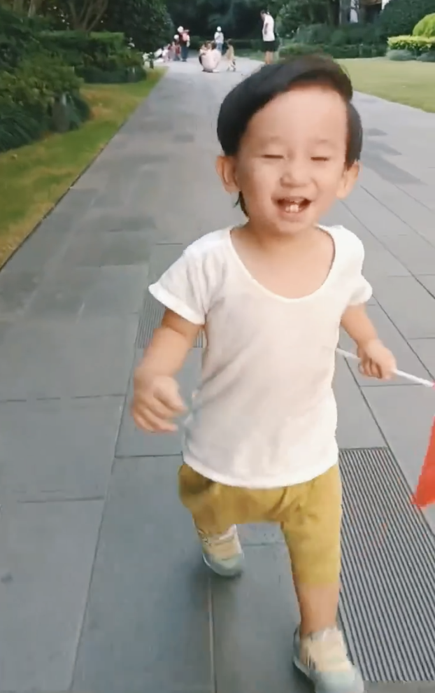 应采儿罕晒次子视频，HoHo举着红旗一路小跑，露小乳牙萌态尽显