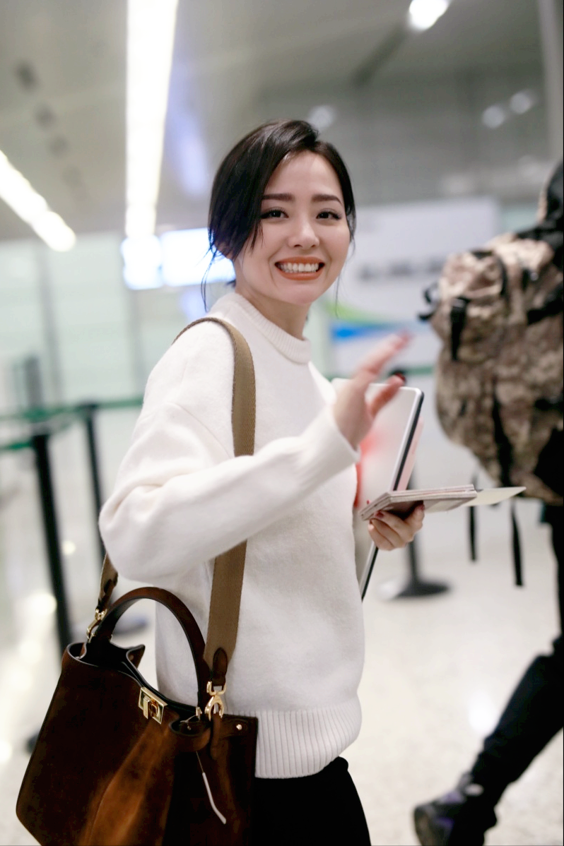 路人镜头下的张靓颖好美,白色毛衣挽起秀发,好似清纯学生妹