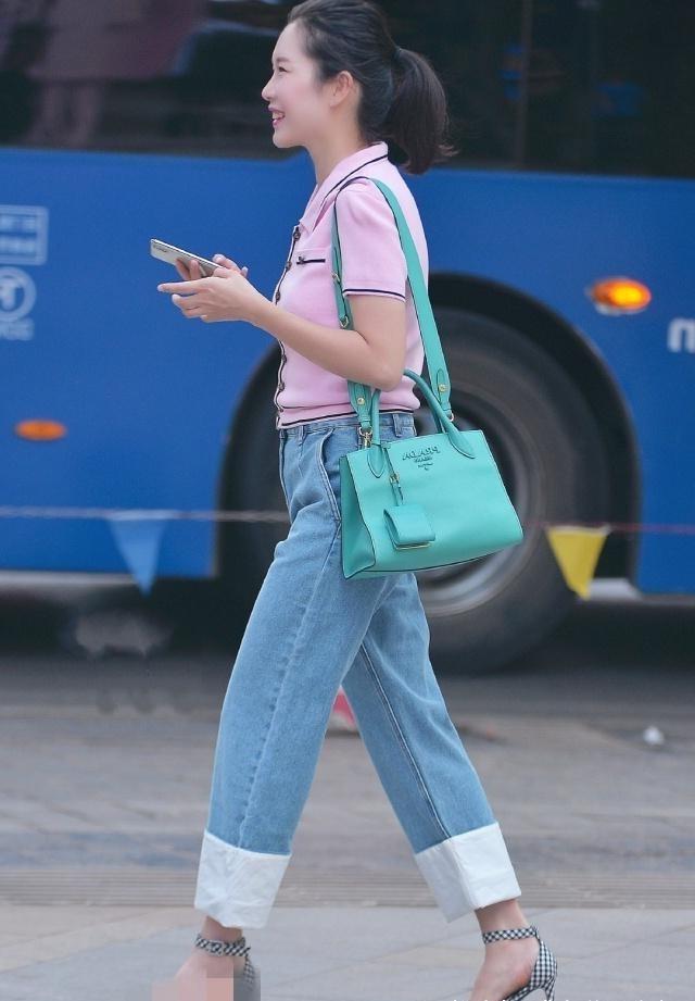 路人街拍，美女上身一件粉色的针织衫，活力十足