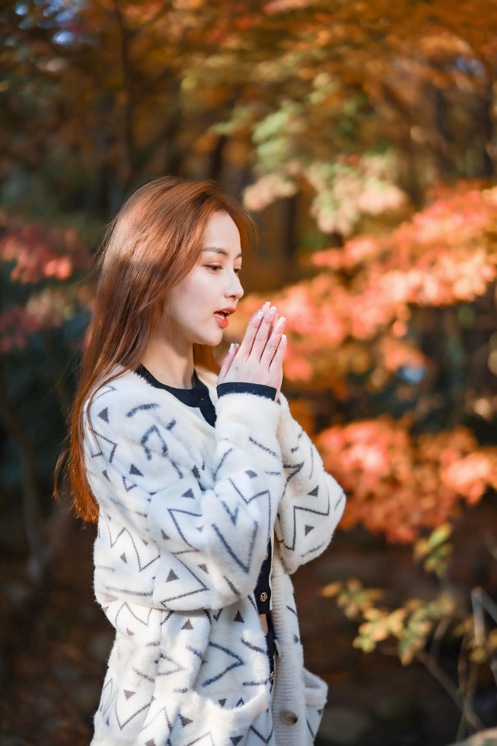 像下面的女生一样,摆一个双手合十,假装哈哈气的姿势,然后从侧面抓拍