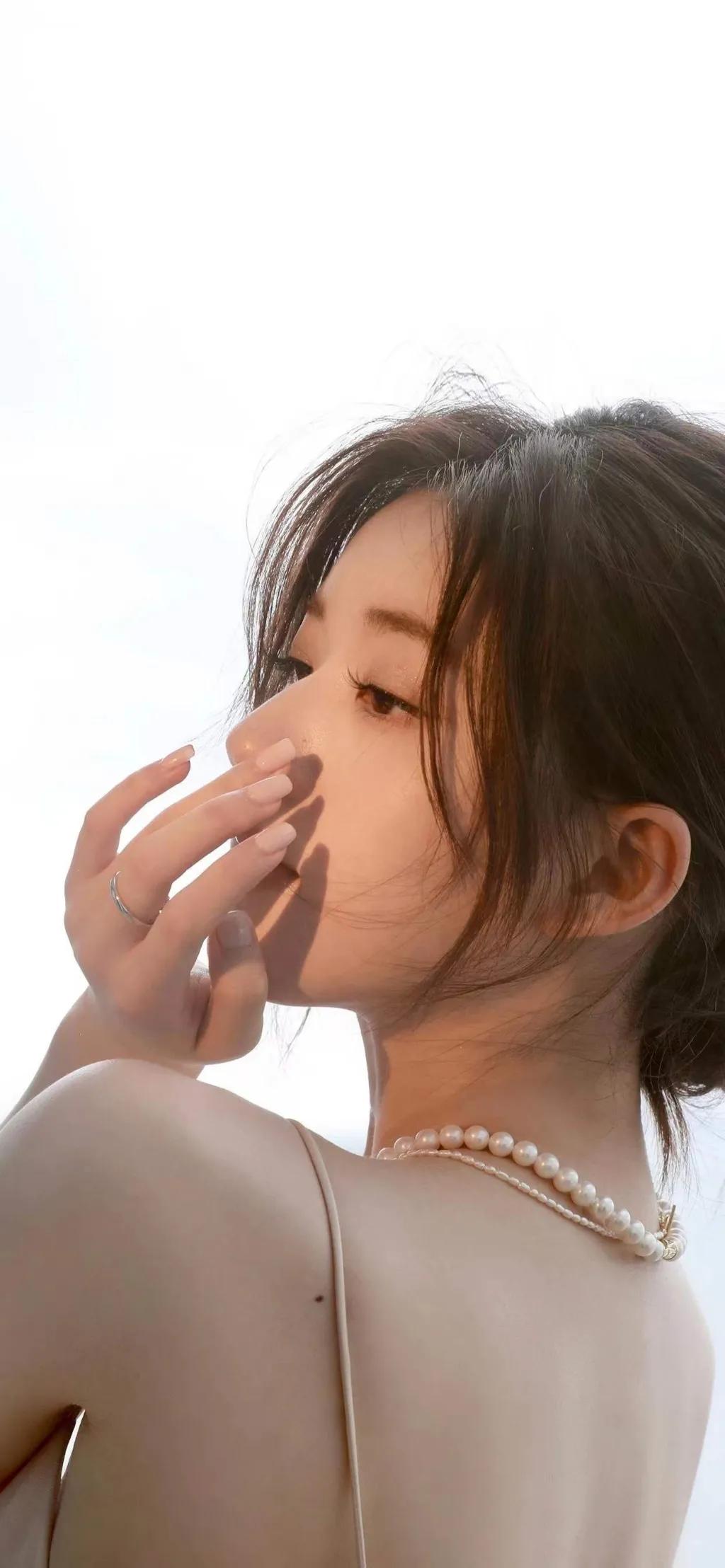 赵露思身穿一身白色珍珠吊带裙，中分盘发造型优雅贵气