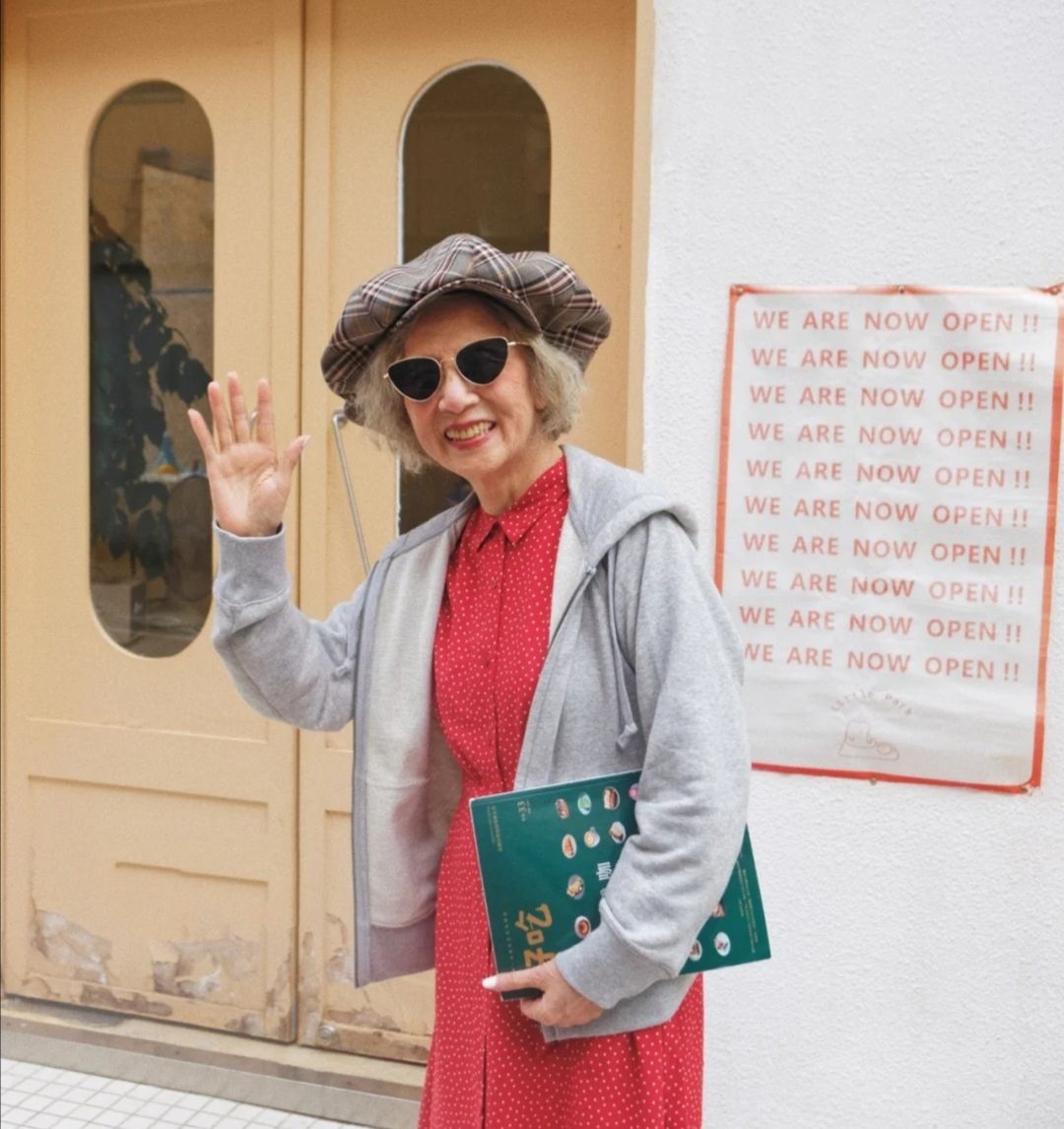 这位八十多岁的奶奶就很会穿衣,一件运动外套搭配红色衬衫裙,一款冷淡