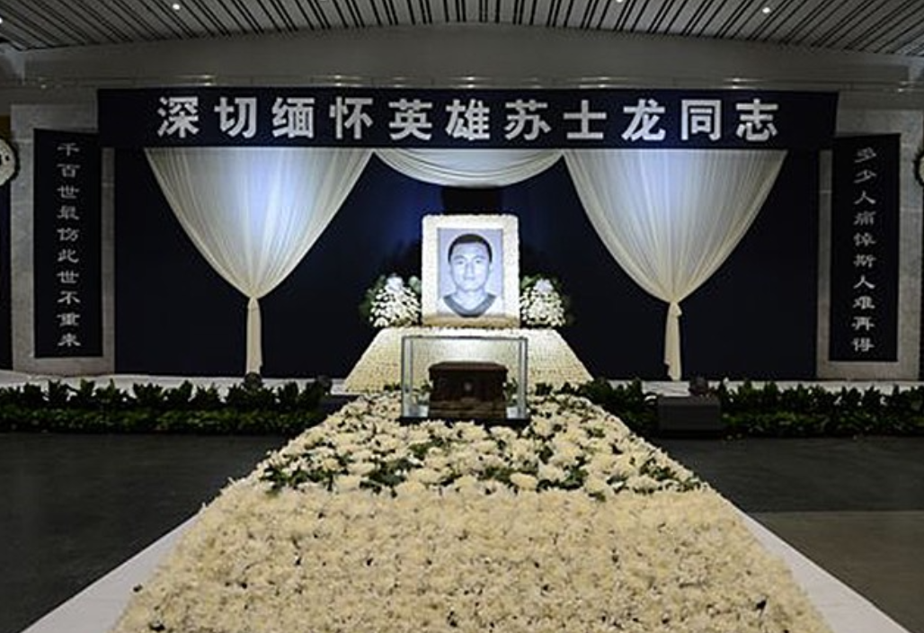 大厅正中央,一个年轻人的黑白遗像正注视着前来吊唁的人.