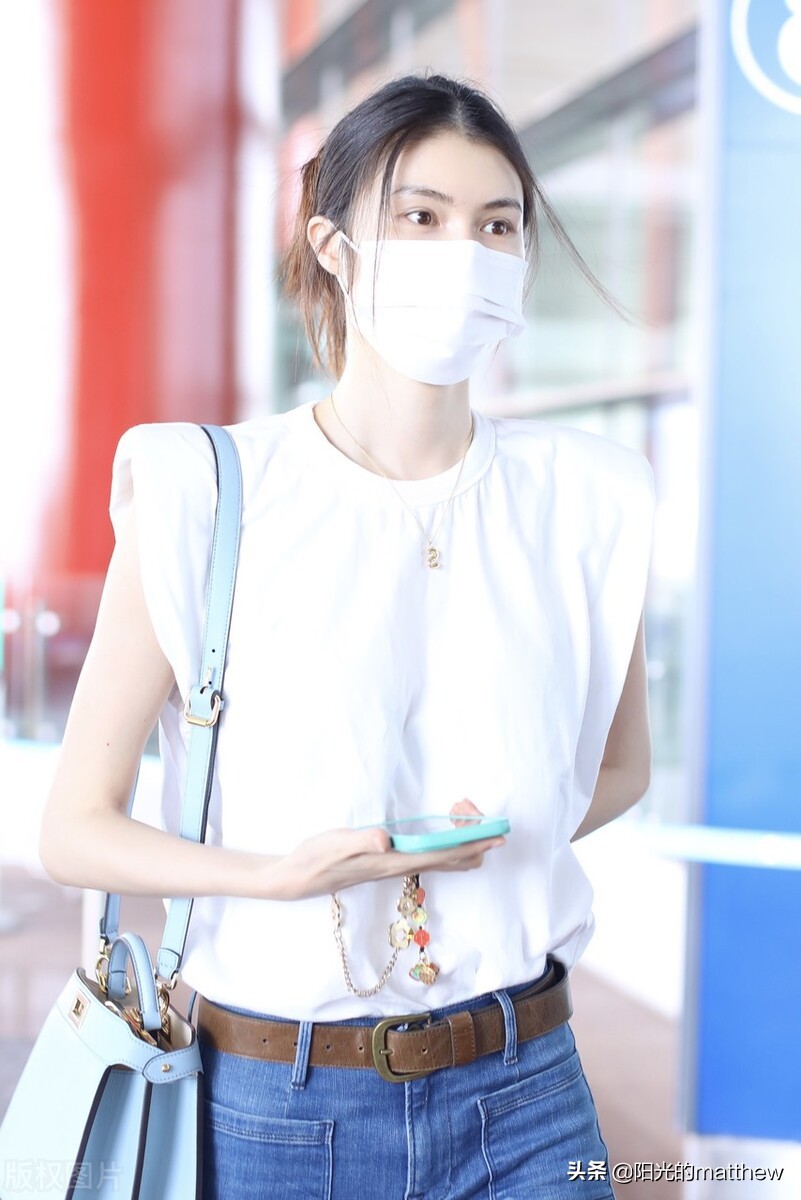 何穗白色无袖上衣搭牛仔裤现身机场背包包气质佳