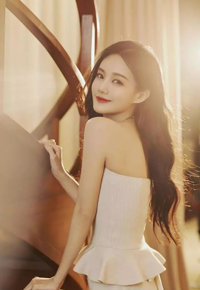 明星**:李一桐白色抹胸长裙时尚艺术照,**浪长发搭配高跟鞋