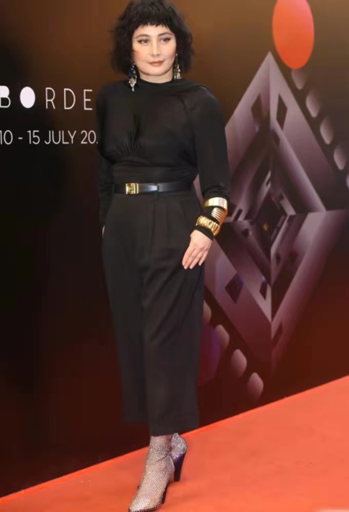 二太去世后何超仪首露面，戴仨金手镯满腰赘肉抢眼，老公一脸沧桑