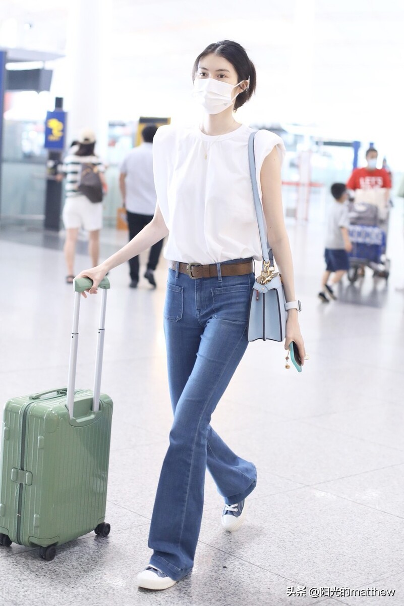 何穗白色无袖上衣搭牛仔裤现身机场背包包气质佳