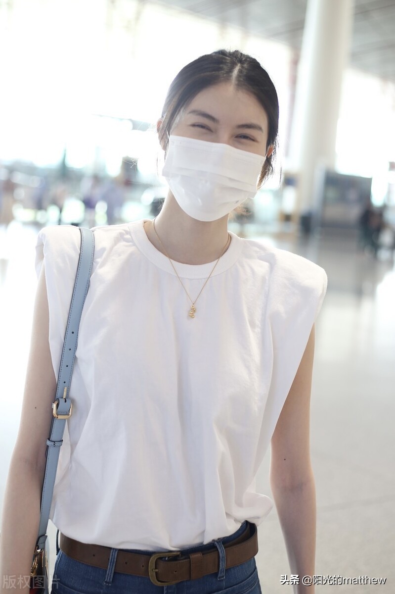 何穗白色无袖上衣搭牛仔裤现身机场背包包气质佳