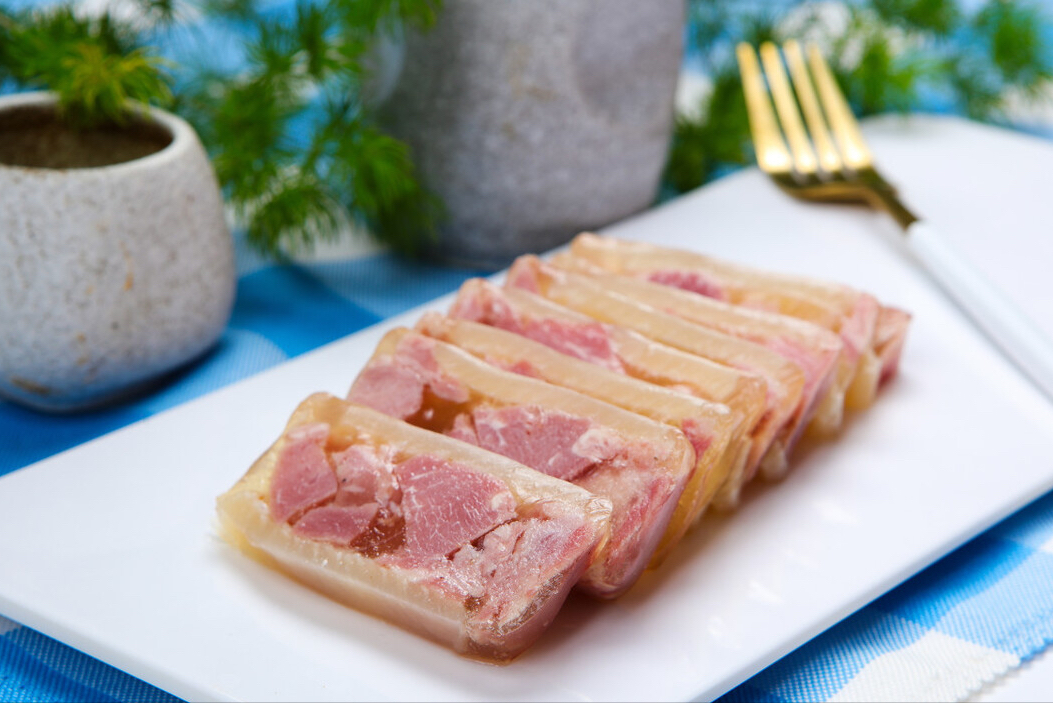 水晶肴肉颜色看起来白里透红,为了将硝味去除便多次清洗后用水焯,接着