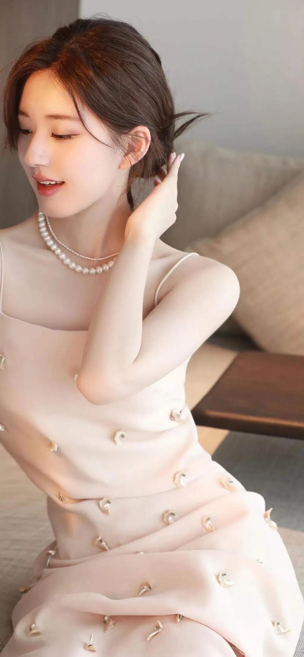 赵露思身穿一身白色珍珠吊带裙，中分盘发造型优雅贵气