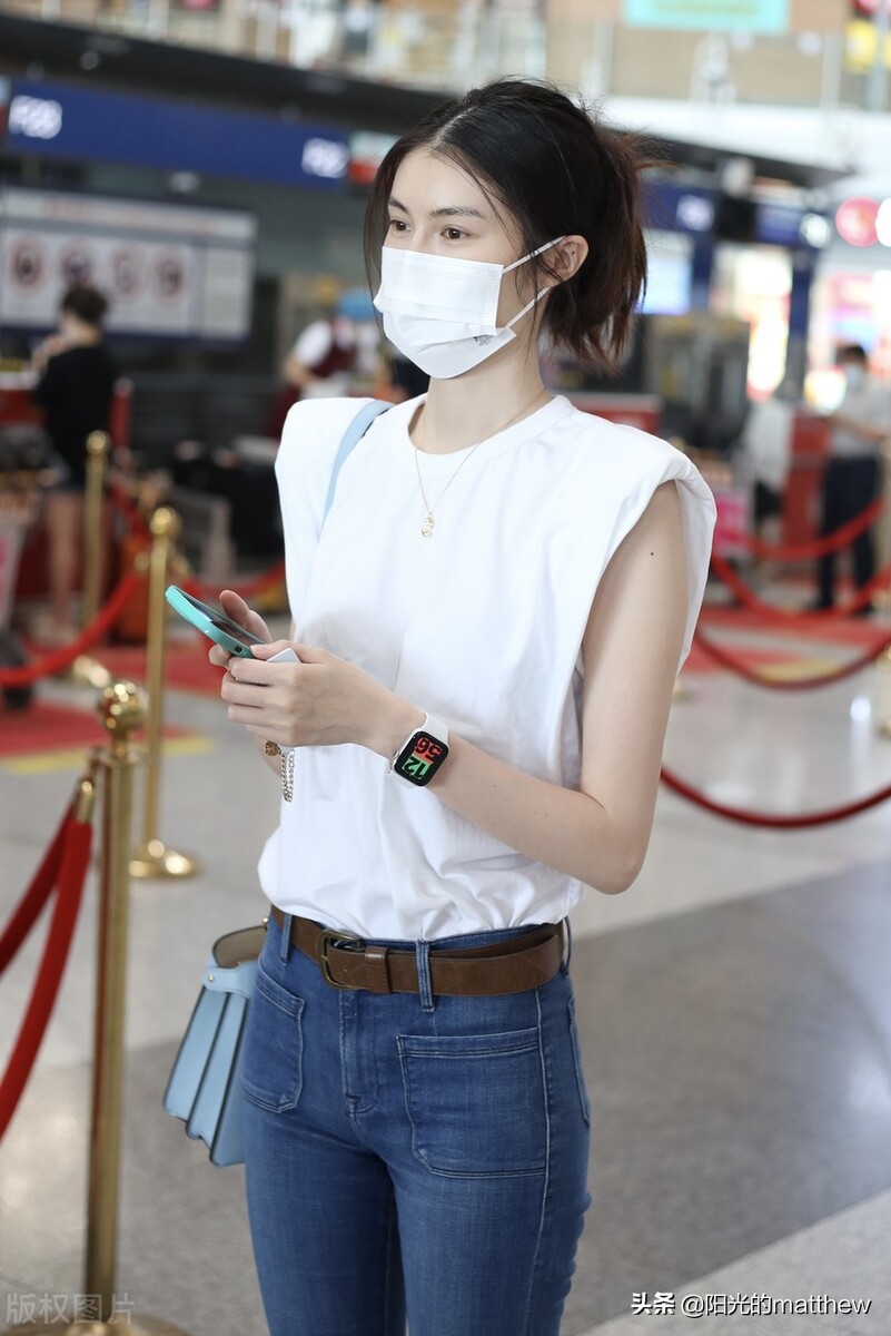何穗白色无袖上衣搭牛仔裤现身机场背包包气质佳