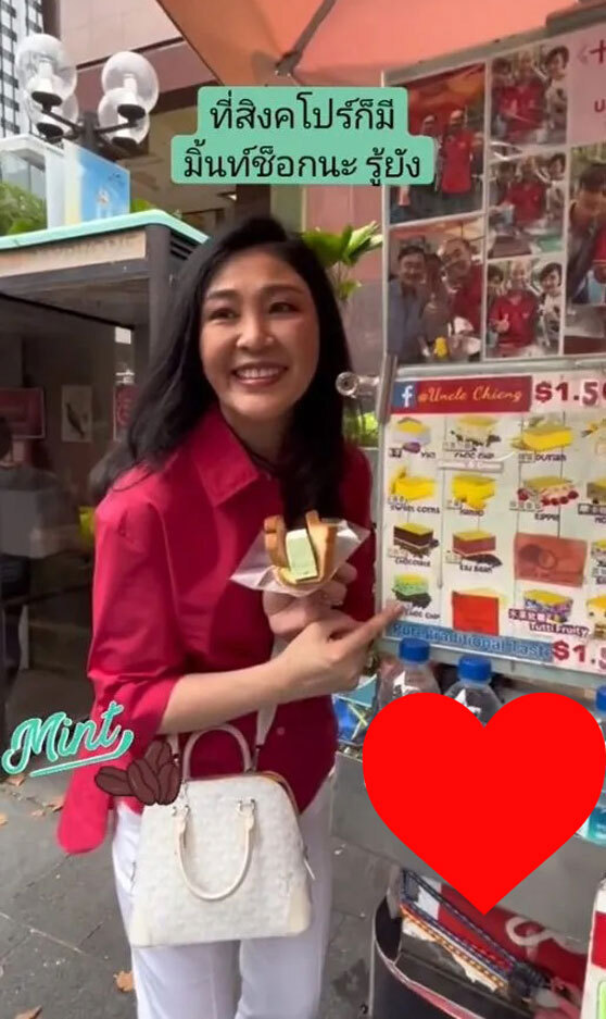 55岁英拉新加坡街头吃冰淇淋，斜挎LV很接地气，浓妆难掩老态