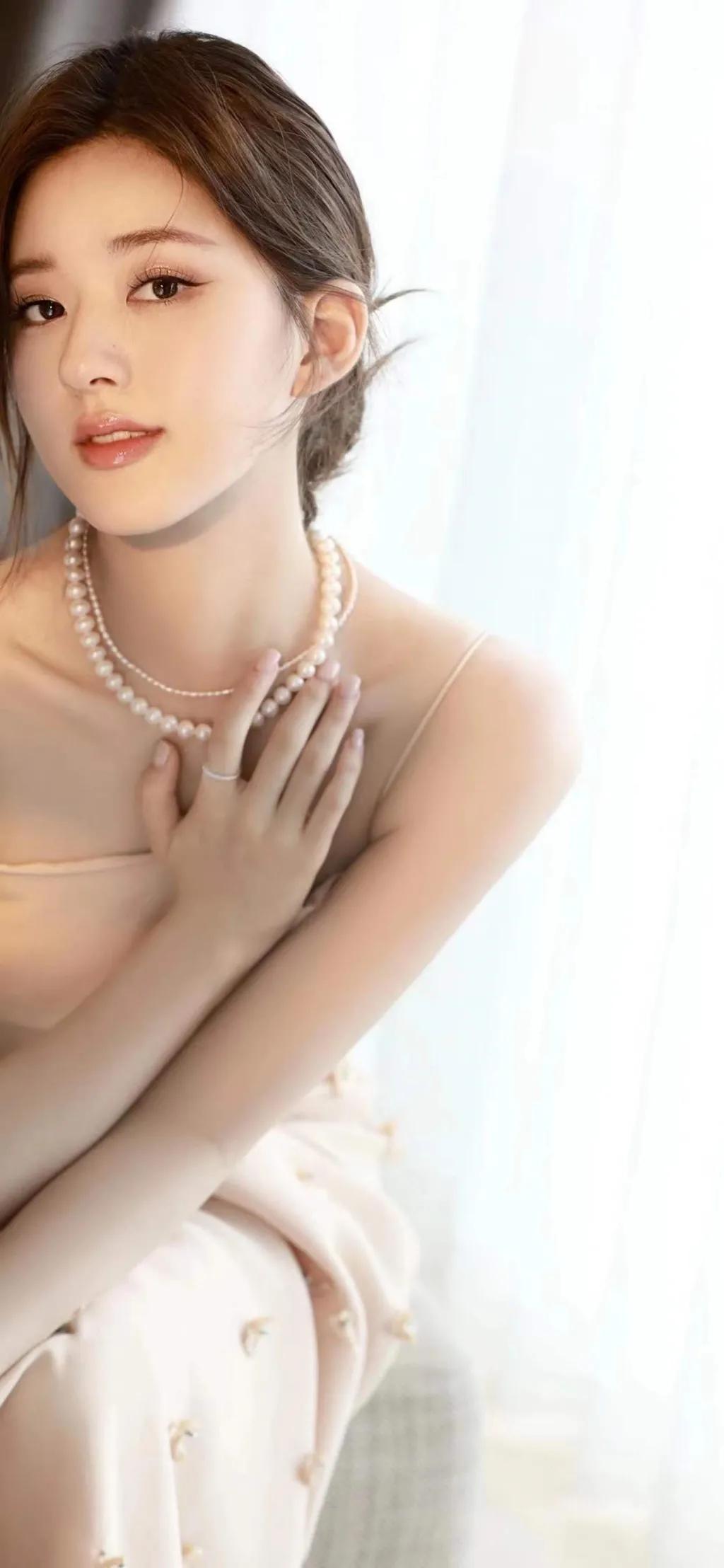 赵露思身穿一身白色珍珠吊带裙，中分盘发造型优雅贵气