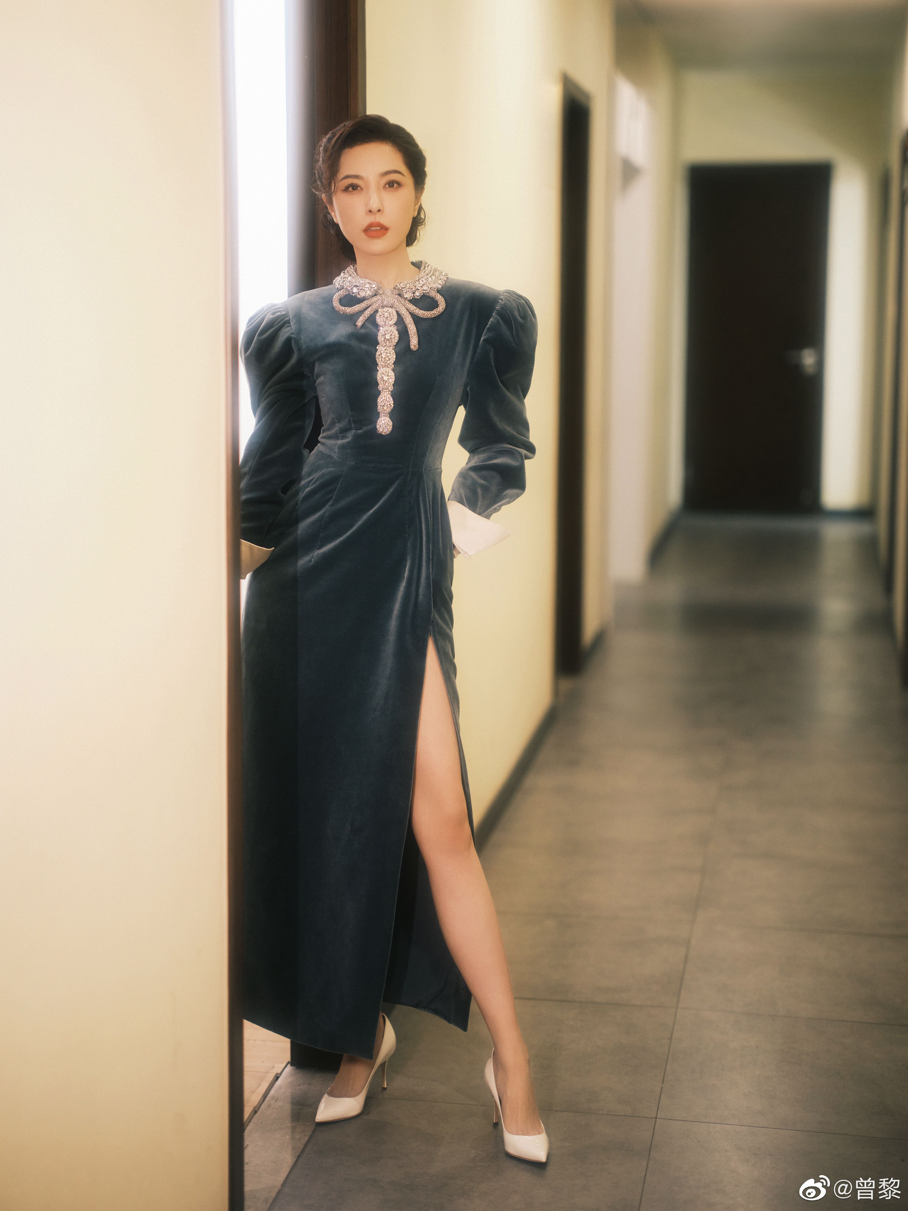 曾黎身穿一袭蓝丝绒连衣裙,银色的领口装饰和夸张的纽扣凸显了服装的