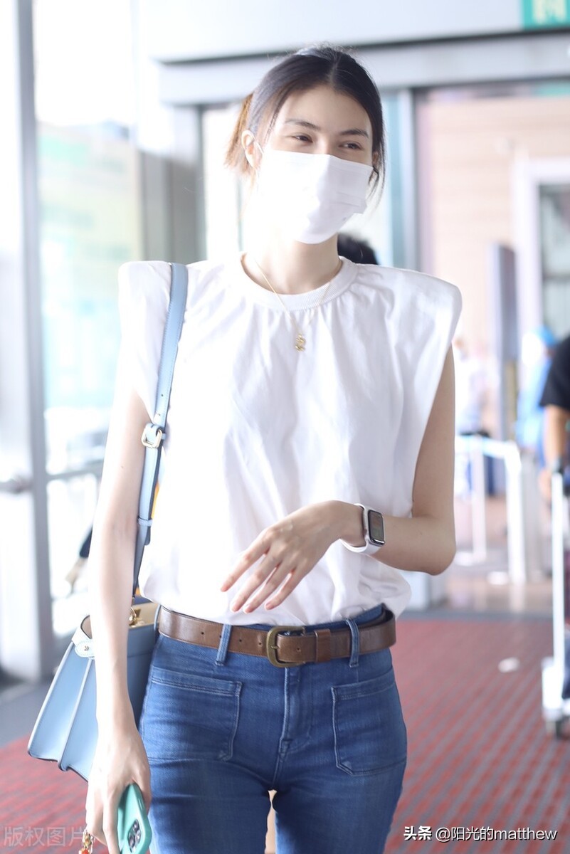 何穗白色无袖上衣搭牛仔裤现身机场背包包气质佳