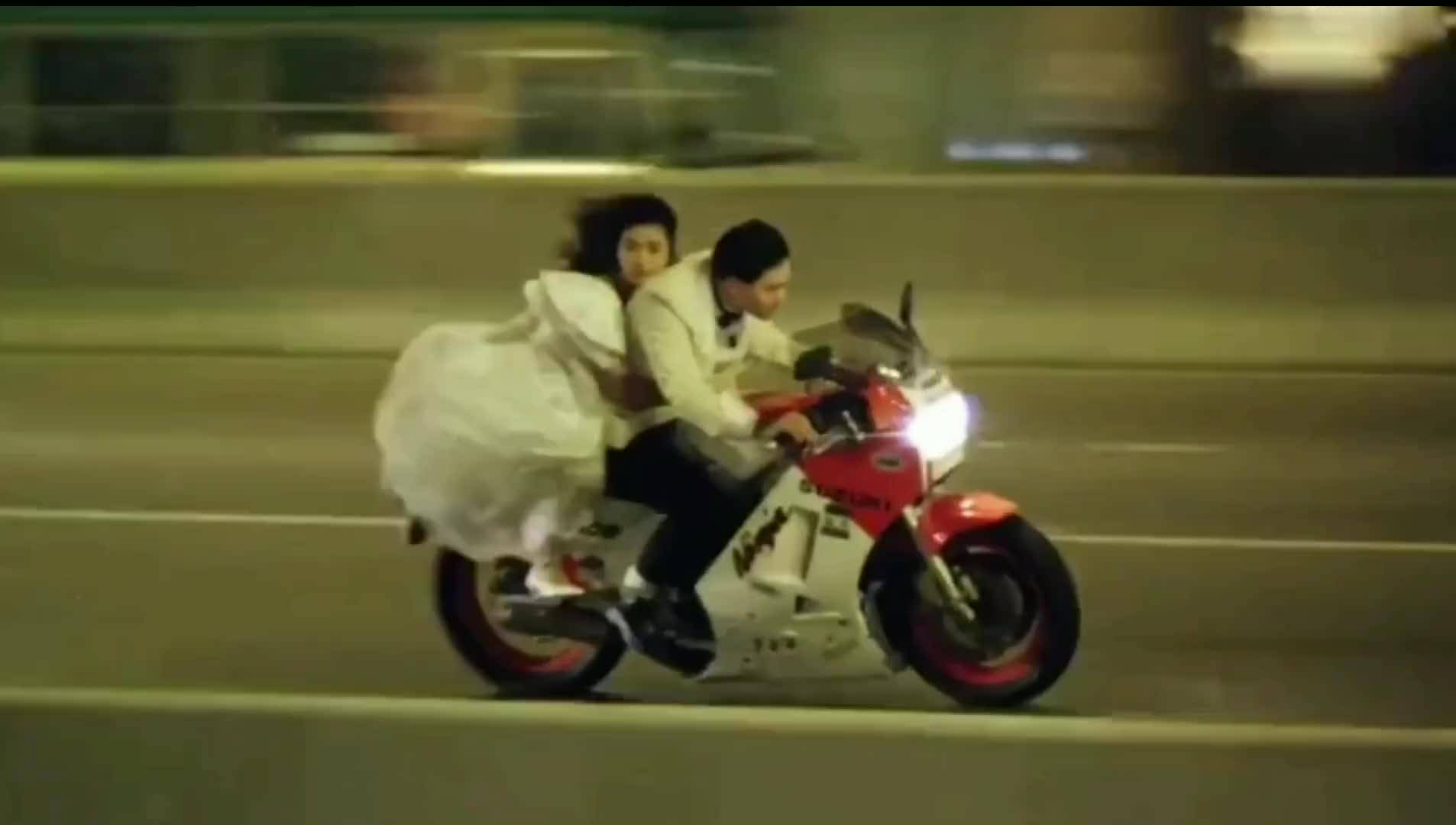 骑着摩托车,一边飞驰一边擦着鼻血,坐在刘德华身后的吴倩莲穿着一袭