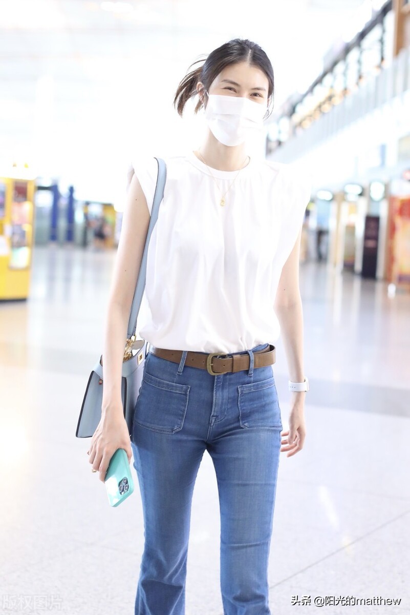 何穗白色无袖上衣搭牛仔裤现身机场背包包气质佳