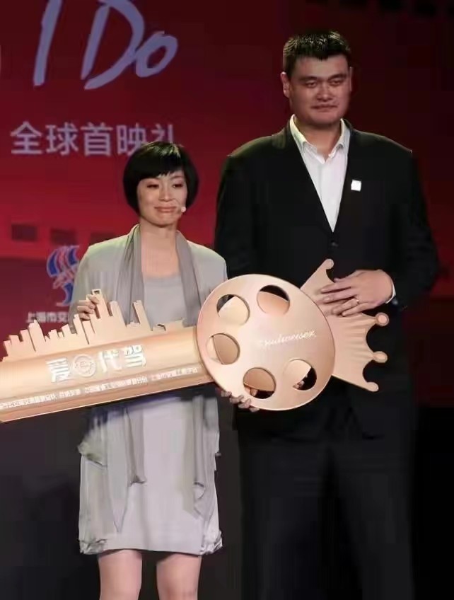 姚明夫妇罕见合体，素色连衣裙风格简约，但和西装搭配未免太普通