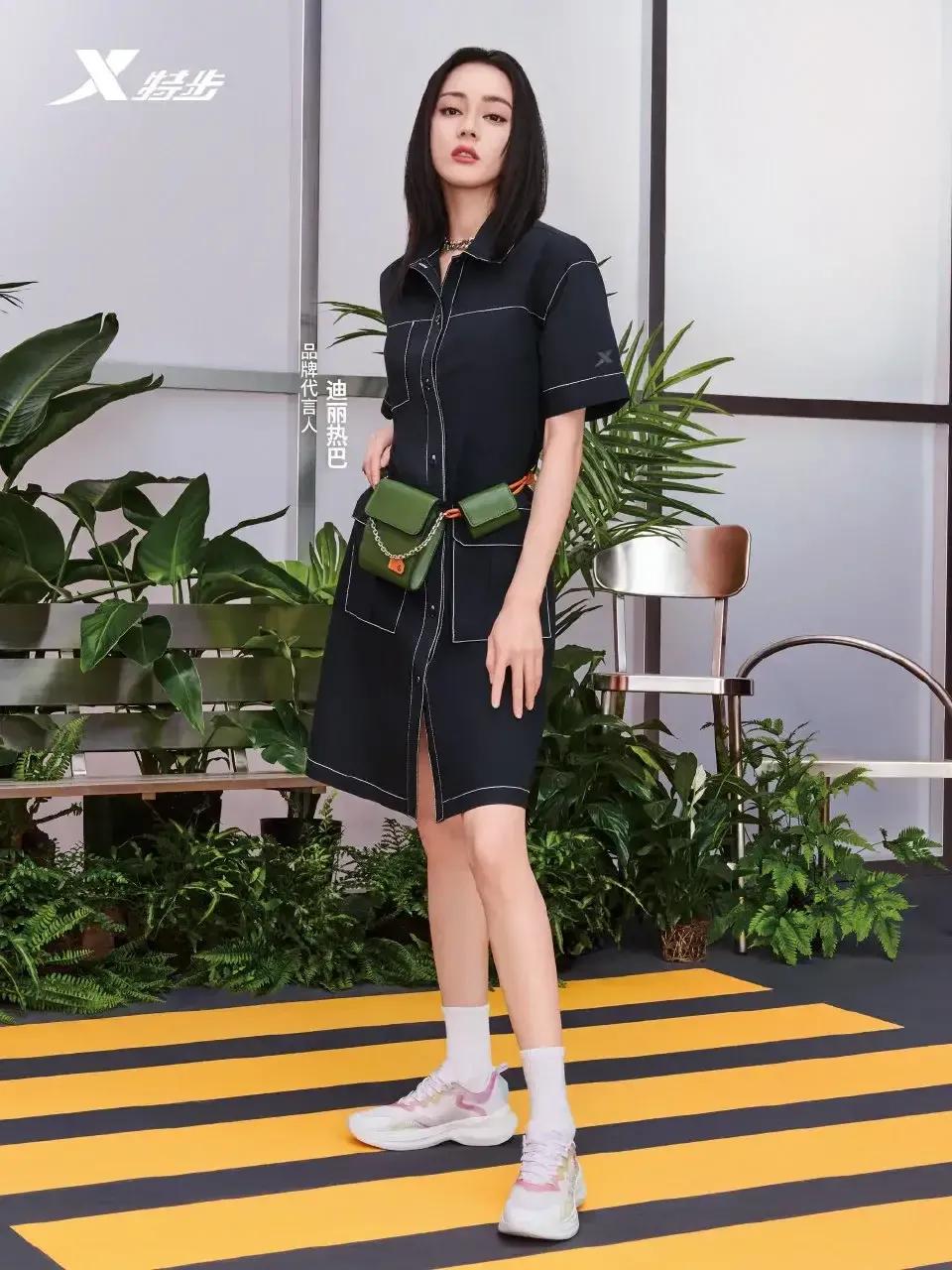 热巴穿黑色裙装，腰间绿色包包醒目