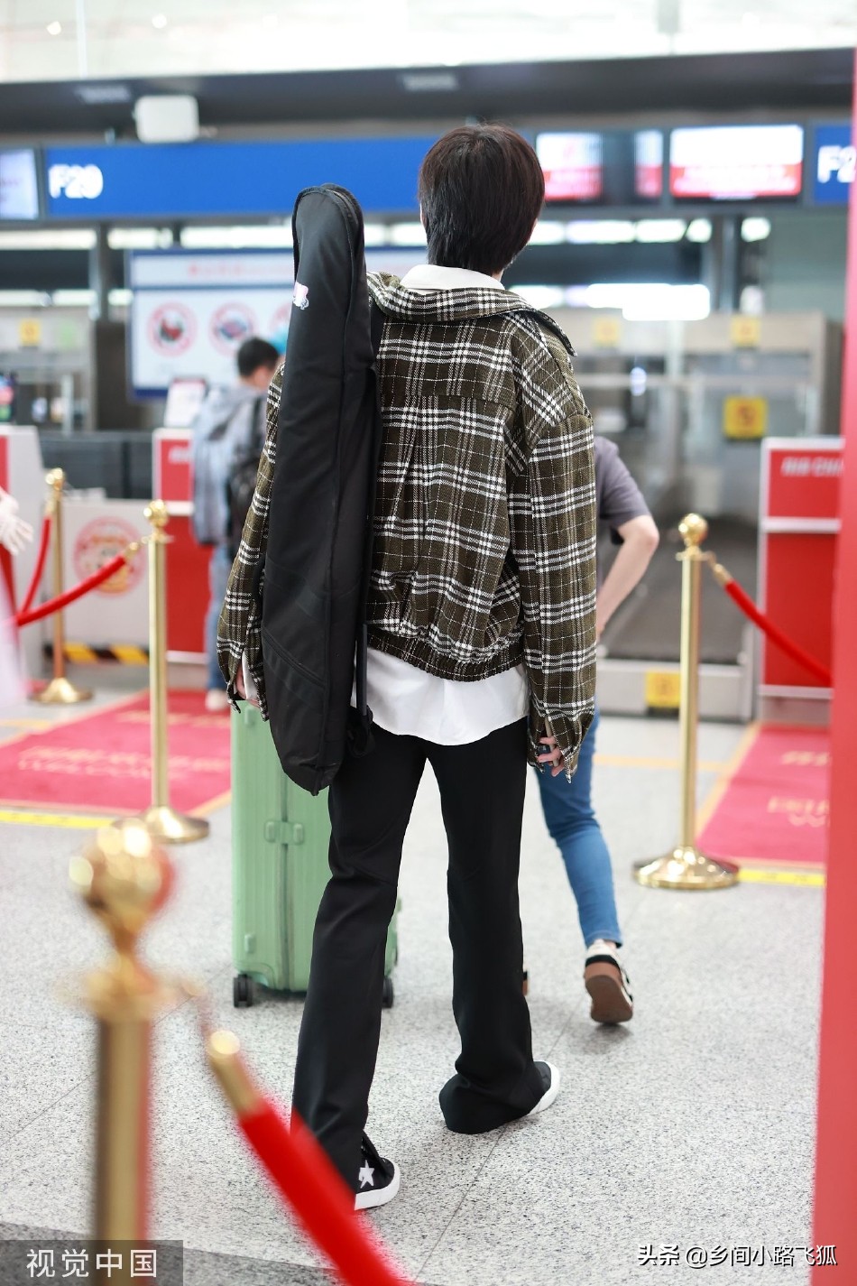 张颜齐休闲穿搭亮相机场 背吉他刘海遮眼慵懒随性