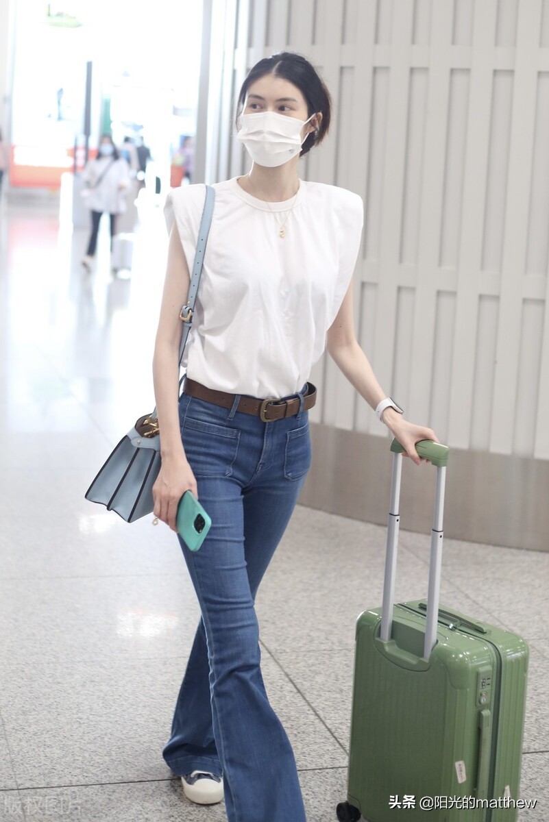 何穗白色无袖上衣搭牛仔裤现身机场背包包气质佳