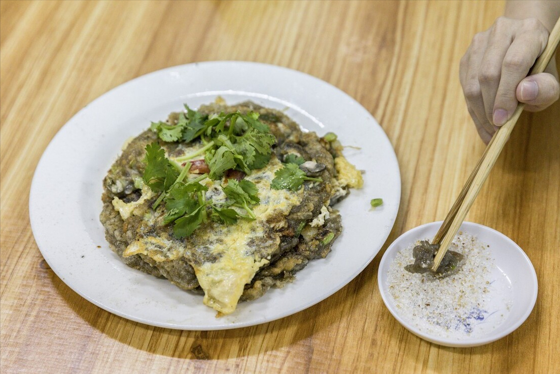 油,在里面炸新鲜的蛤蜊,然后把浆糊倒在虫子身上,煎好后翻面继续煎