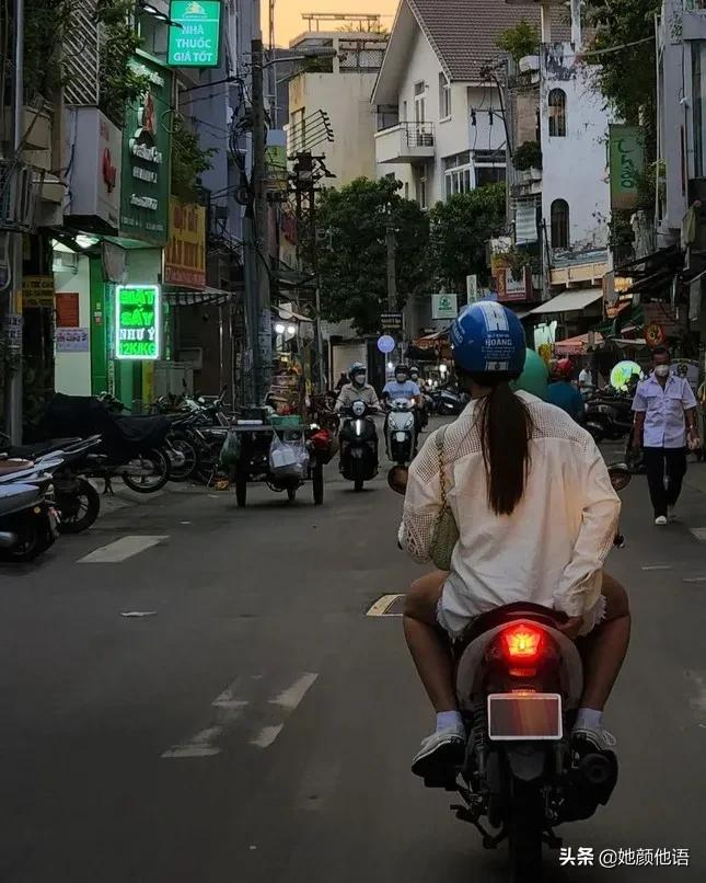 衣着质朴的环球小姐卡特里奥娜·格雷骑着摩托车在胡志明市逛街