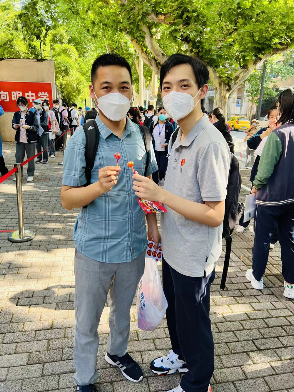 2022年6月参加等级考,卢湾高级中学化学老师(左)送考,为郭奕添(右)